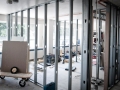 Interior renovation with exposed metal wall framing, drywall panels, and construction tools