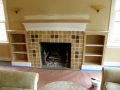 Beige tiled fireplace with built-in shelves on both sides during renovation