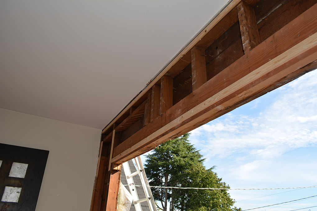 Exposed wood framing above a large wall opening during renovation