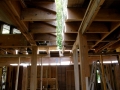 Exposed wood framing and ceiling joists inside a home under construction