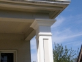 White decorative porch column with layered trim supporting a gray roof overhang
