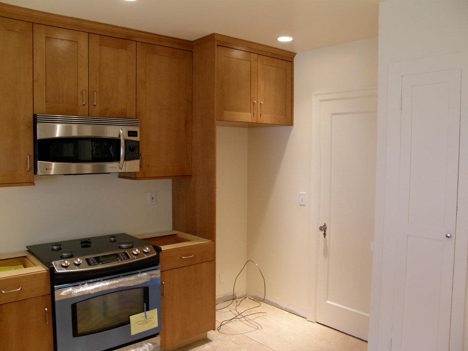 Renovated kitchen with wood cabinets, stainless steel range, and microwave