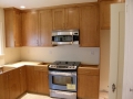 Wood kitchen cabinets with stainless steel range and built-in microwave