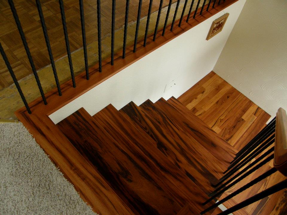 Wood staircase and landing with black metal balusters viewed from above
