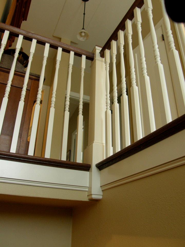 White turned stair spindles with dark wood railings around an upstairs landing