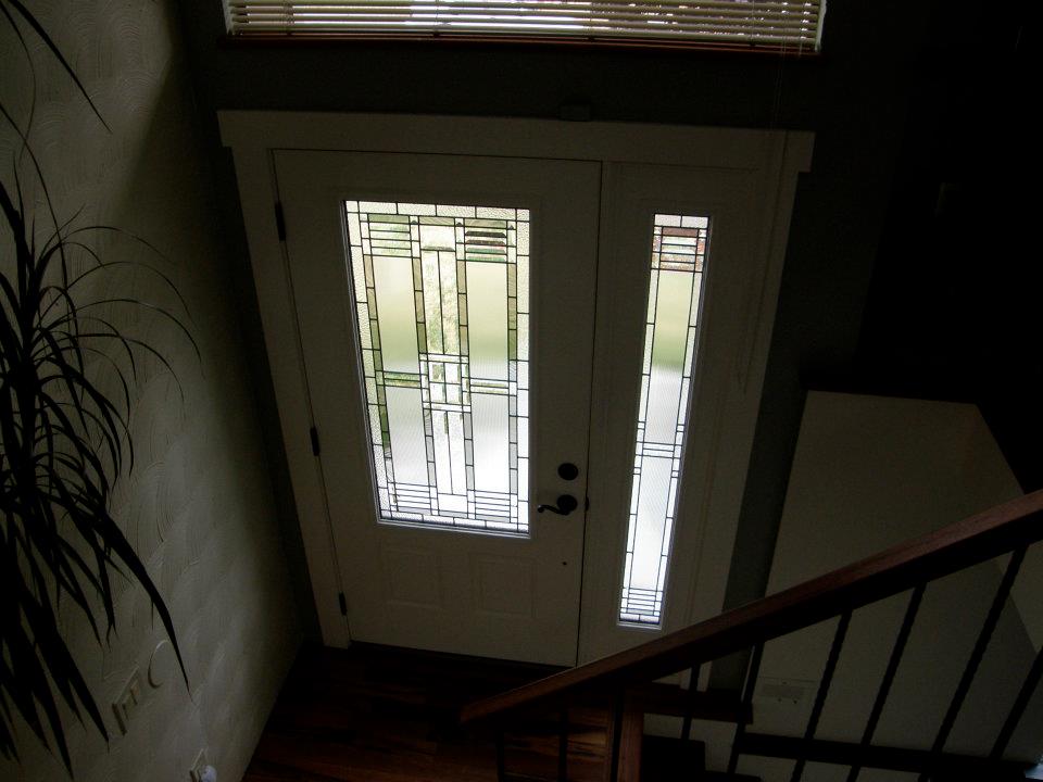 White front door with decorative glass panel and matching narrow sidelight