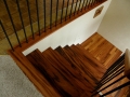 Wood staircase and landing with black metal balusters viewed from above
